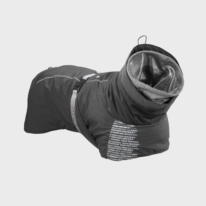 Dog jacket lying flat, featuring a high collar, adjustable strap, and reflective patterns, set against a simple gray background.