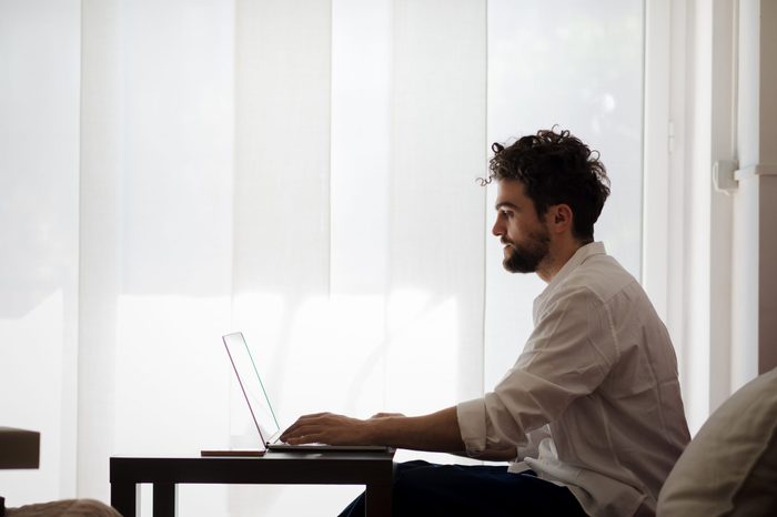 handsome hipster modern man designer working home using laptop at home