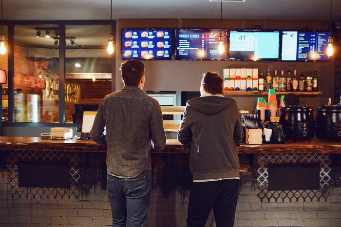 Two men choose food in a fast food restaurant.