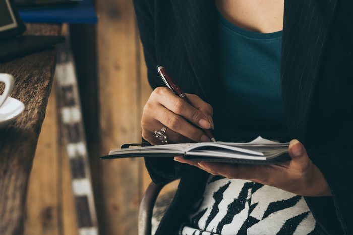 home office desk background,hand holding pencil and writing note on wood table,Checklist Notice Remember Planning Concept