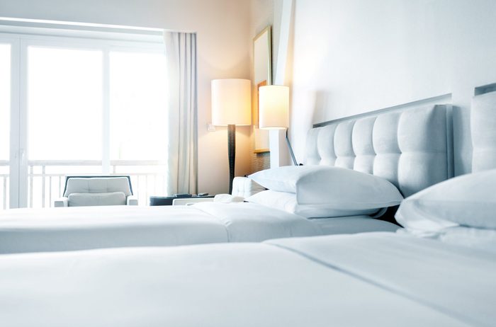 made beds in a simple white hotel room