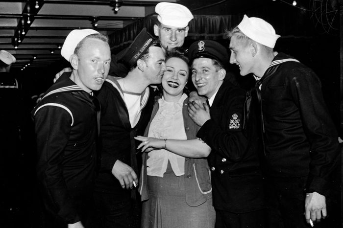 United States and British troops pose for the camera with a woman, circa 1940s