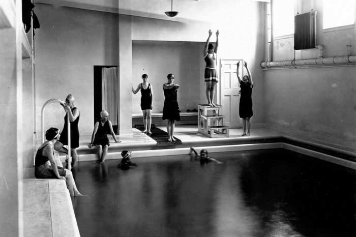 Young women sit around an indoor swimming pool at Mount Vernon Seminary. Washington, D.C., circa 1900
