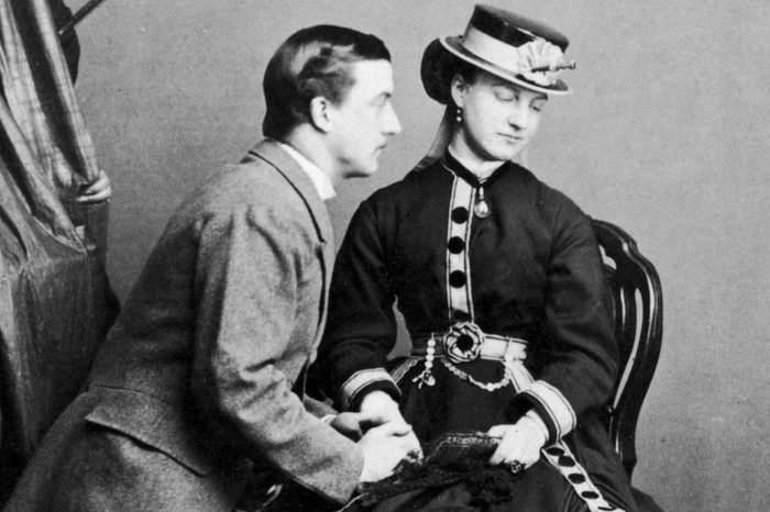 Lord Algernon of Lennox kneels in supplication before a young woman, circa 1880