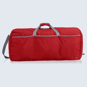 Red duffel bag resting on a reflective surface, featuring gray straps and a front zipper pocket, set against a light background.