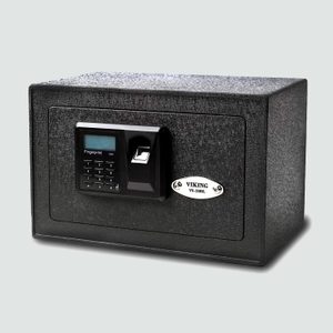 A black electronic safe with a keypad and fingerprint scanner stands against a plain background. Plaque reads 