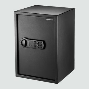 A black safe with a keypad lock stands upright, labeled 