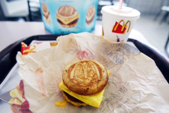 a sausage egg and cheese mcgriddle breakfast on a try with drink in a mcdonalds restaurant