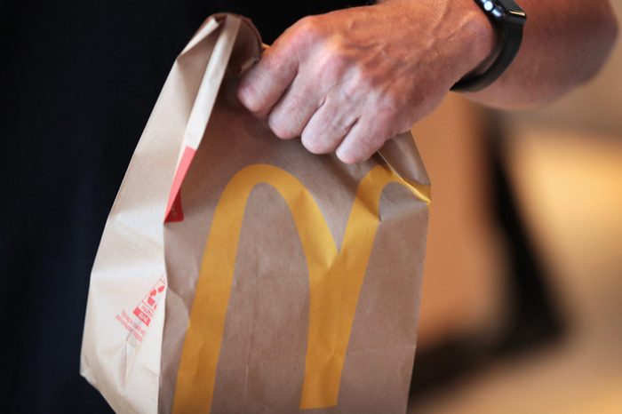 hand holding a mcdonalds paper bag