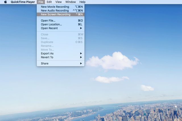 Menu options display QuickTime recording functions over a cityscape view under a clear blue sky with scattered clouds.