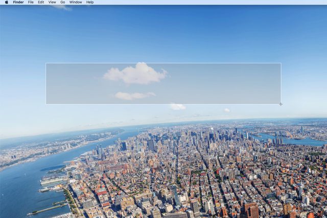 Aerial cityscape shows dense buildings beside rivers under a clear sky with clouds. Computer toolbar visible at the top of the screen.