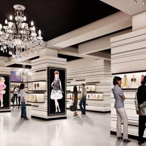 Visitors examine detailed dolls displayed in a well-lit exhibition room, adorned with elegant chandeliers, creating a sophisticated atmosphere.
