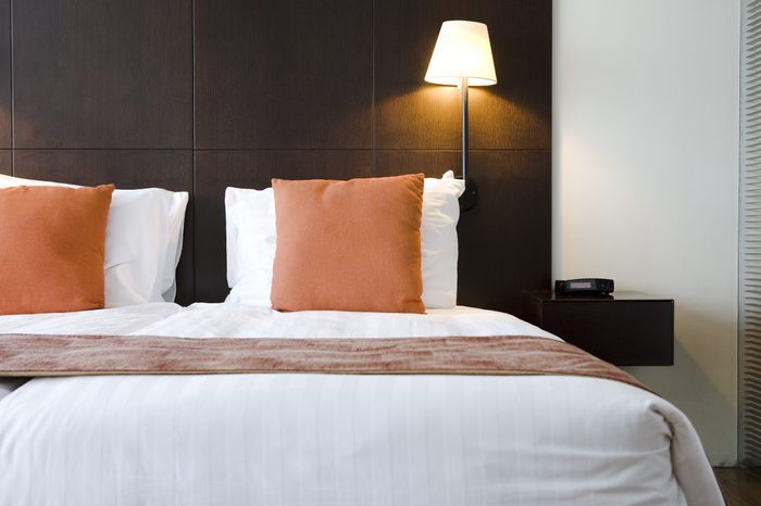 Bed in hotel room with orange pillows