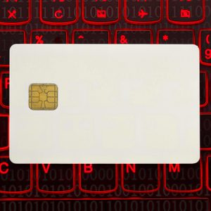 A blank card with a chip rests on a keyboard with glowing red symbols and binary numbers in the background.