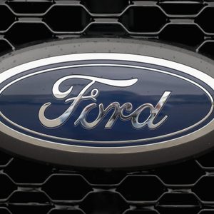 Ford logo, affixed prominently, on a black vehicle grille with hexagonal pattern background.