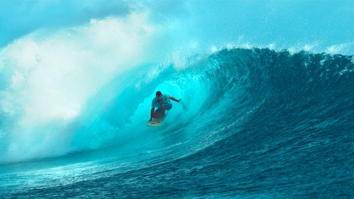 CLOSE UP: Fearless young surfboarder rides inside a spectacular barrel wave.