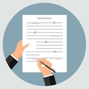 Hands hold and mark a document with red pen corrections, against a simple blue-gray circular background.