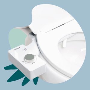 A bidet attachment with control knobs is installed on a white toilet seat, set against a light blue background.