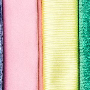 Four colorful fabric textures aligned vertically; blue grid, pink smooth, yellow striped, and green terry, showing different textile weaves.