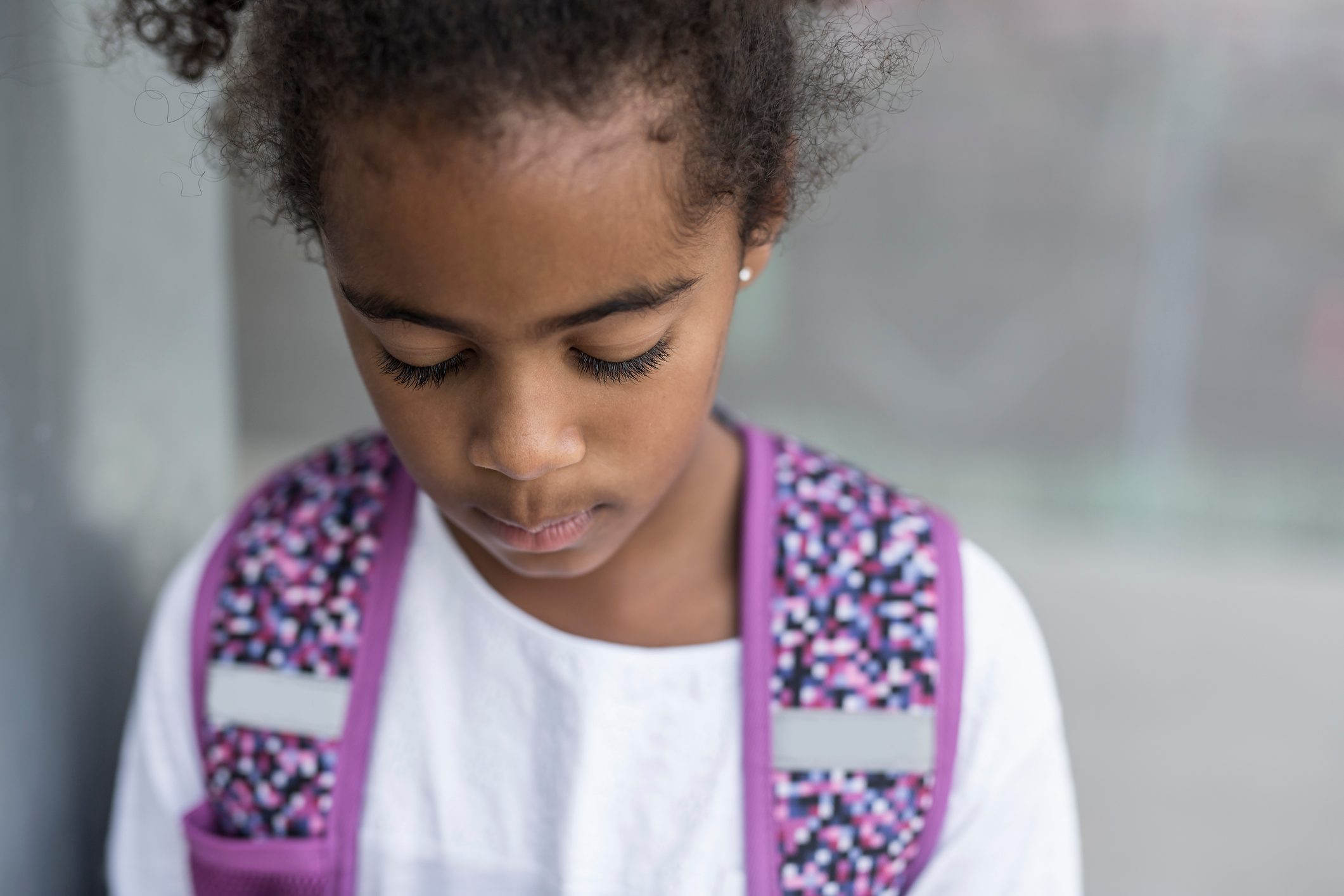 cheerful african american primary school girl with backpack