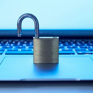 An open padlock sits atop a laptop keyboard, symbolizing cybersecurity concerns in a digital environment.
