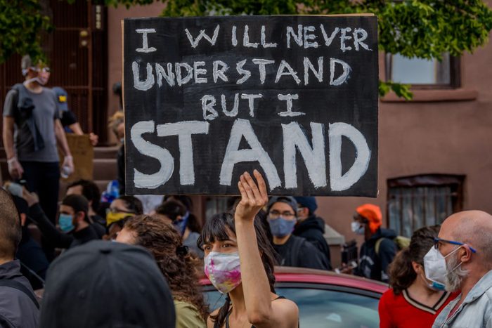 A participant holding a sign at the protest. Thousands of...