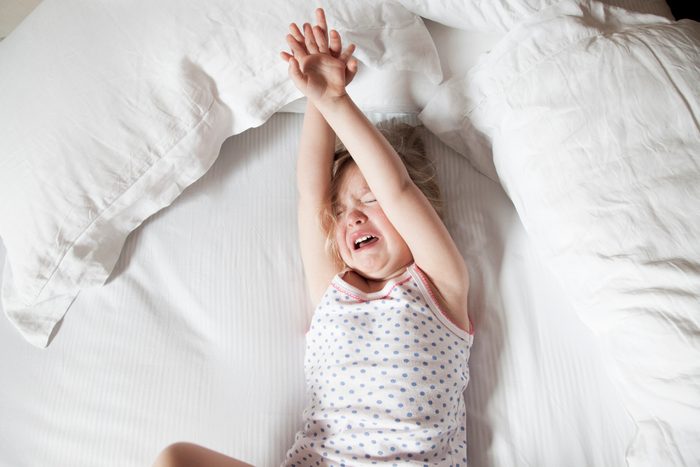 Little girl crying in bed