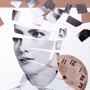 Collaged face, fragmented, with scattered paper pieces and a partial clock face in a layered artistic composition on a cardboard background.