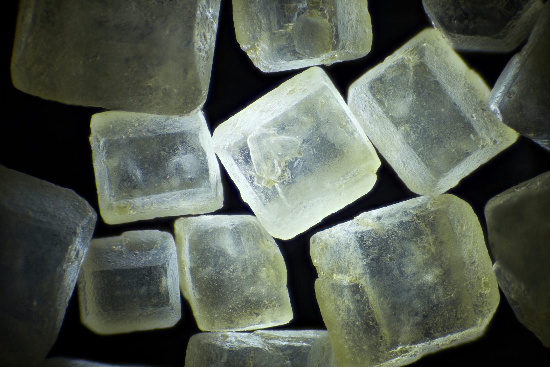 Brown sugar on black background microscopic image, dark field technique, magnification x 40