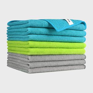 Stacked microfiber cloths, arranged neatly in blue, green, and gray, against a plain background. A small tag is visible on the top cloth.