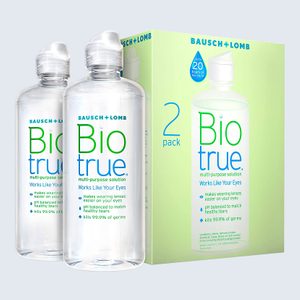 Two Biotrue bottles for contact lens care stand near a green box labeled 