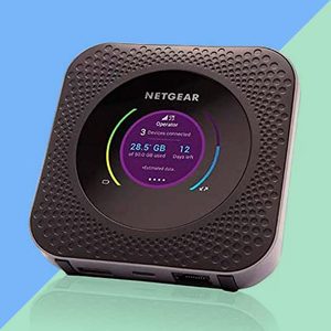 A black Netgear mobile hotspot displays data usage and days left on its screen, against a blue and green background.