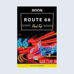 Neon signs illuminate; a retro car and road with 