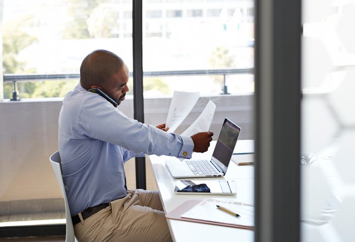 Businessman on phone and looking threw papers
