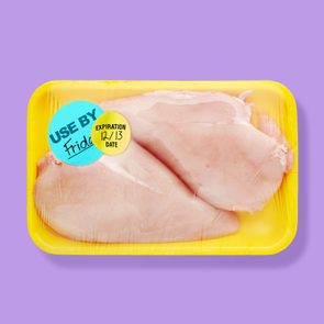 Packaged chicken sits in a yellow tray, wrapped in plastic, with 