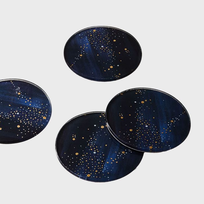 Four round coasters display a starry pattern against a dark blue background, arranged on a plain white surface.