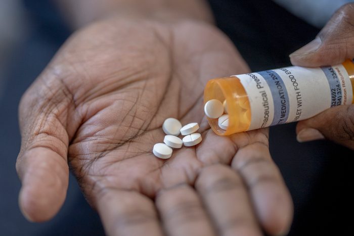 Mature male pouring medicine into his hand