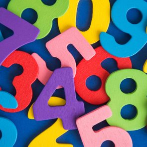 Colorful wooden numbers are scattered randomly against a blue background.