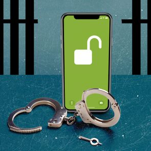 Smartphone displays an unlocked padlock icon; handcuffs and key lie nearby, against a textured surface with bars in the background.