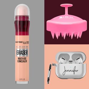 A concealer tube stands upright; a pink scalp brush rests with bristles downward; earphones sit in a personalized case with 