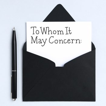 A black pen lies beside a black envelope containing a letter reading "To Whom It May Concern:" on a light background.