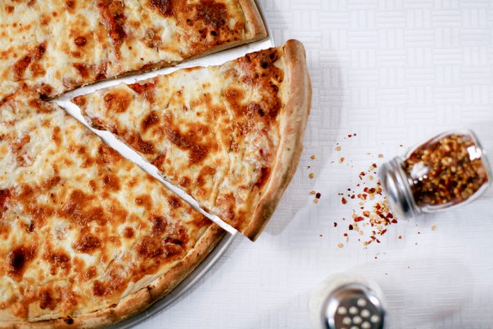 Pizza slice with spilled chili flakes