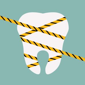 A white tooth is wrapped with yellow and black caution tape on a teal background.