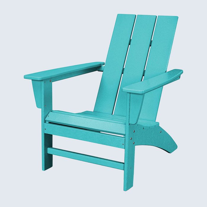 A turquoise Adirondack chair stands stationary against a plain, light background.