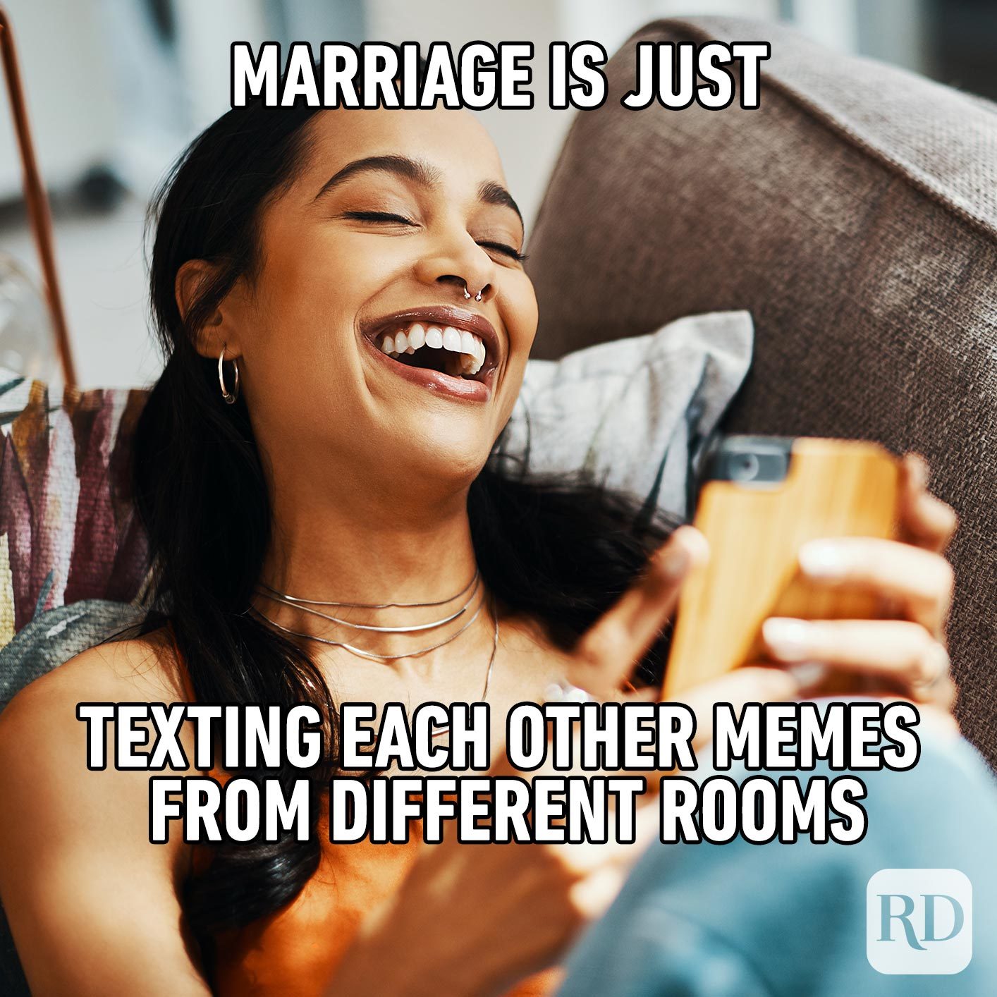 Woman laughing at phone. Meme text: Marriage is just texting each other memes from different rooms