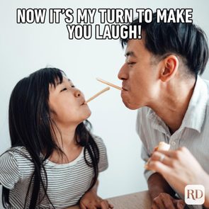 Two people balancing sticks with mouths, playing gleefully at a table. Text above reads, 