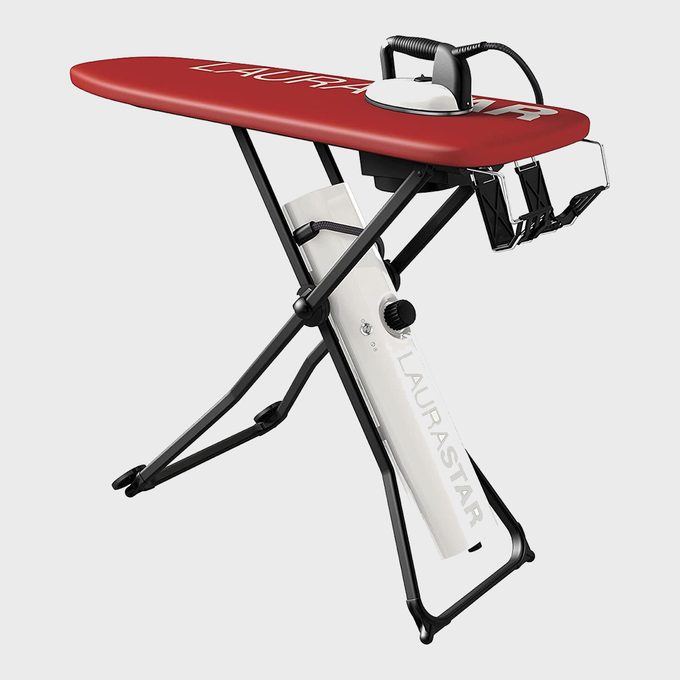 Red ironing board holds iron; black metal legs support. White base with 