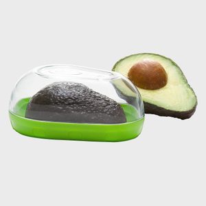 Avocado half is stored in a clear plastic container with a green base, next to another avocado half on a plain background.