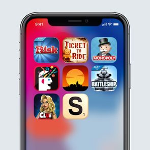 Smartphone screen displays game app icons, including Risk, Ticket to Ride, Monopoly, and Battleship, set against a colorful gradient background.