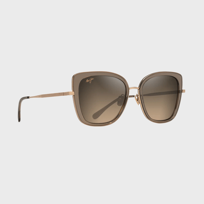 Sunglasses rest on a white background, featuring square, brown-tinted lenses and thin gold frames. Small logo text appears on the lens.
